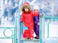 Little children in winter clothes having fun on playground at the snowy winter day Royalty Free Stock Photo