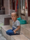 Little Chinese boy playing on a narrow alley of Xiaozhou Village, China