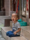 Little Chinese boy playing on a narrow alley of Xiaozhou Village, China