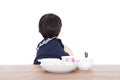 Little Chinese girl refusing to eat at the table in front of white background Royalty Free Stock Photo