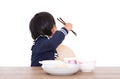 Little Chinese girl refusing to eat at the table in front of white background Royalty Free Stock Photo