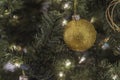 A gold and glittery ornament on a Christmas tree w Royalty Free Stock Photo