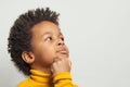 Little clever curious black child boy thinking on white background, close up portrait Royalty Free Stock Photo