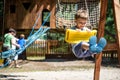 Little climber takes the rope bridge. Boy has fun time, kid climbing on sunny warm summer day Royalty Free Stock Photo