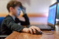 Little computer dependent gamer boy playing on laptop Royalty Free Stock Photo