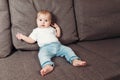Little contented happy baby boy with pacifier sitting on a bed or a sofa. The only child in family Royalty Free Stock Photo