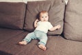 Little contented happy baby boy with pacifier sitting on a bed or a sofa. first year of life in family Royalty Free Stock Photo