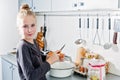 Little cook girl breaks eggs in a deep dish Royalty Free Stock Photo
