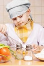 Little cook whisking eggs in a bowl Royalty Free Stock Photo