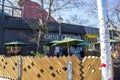 The Little 5 Corner Tavern with green umbrellas and bare winter trees and a clear blue sky in Little Five Points in Atlanta