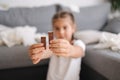 Little crafty girl eats sweets at home. Kid eating chocolate and have fun. Chaos at home. Focus on hands Royalty Free Stock Photo