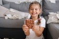 Little crafty girl eats sweets at home. Kid eating chocolate and have fun. Chaos at home Royalty Free Stock Photo