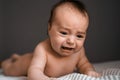 Little crying baby daughter on bed. One month age. Newborn cute happy beautiful girl smiling. Breast-feeding. Happiness Royalty Free Stock Photo