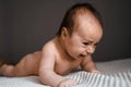 Little crying baby daughter on bed. One month age. Newborn cute happy beautiful girl smiling. Breast-feeding. Happiness Royalty Free Stock Photo