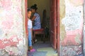 A little cuban girl peeking form behind the door