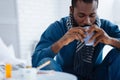 Unemotional quiet man drinking from his cup