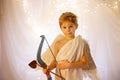 Little cupid toddle boy, holding bow and arrow, beautiful blond cherub