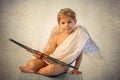 Little cupid toddle boy, holding bow and arrow, beautiful blond cherub