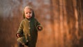 Little curious boy in knitted sweater on walk in autumn nature, looking at camera. Royalty Free Stock Photo