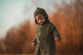 Little curious boy in knitted sweater on walk in autumn nature, looking at camera. Royalty Free Stock Photo