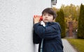 A little curious caucasian boy overheard a conversation through the wall using a cup. Face expression close up portrait Royalty Free Stock Photo