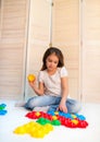 Little curious girl lays plastic puzzles