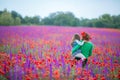 Little curly blond boy and girl play in poppy flower field. Child picking red poppies. Toddler kid in summer meadow Royalty Free Stock Photo