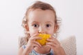 Little curly cute girl eating corn sitting on the chair