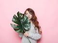 Little curly girl child wearing pink outfit and holding flower Royalty Free Stock Photo