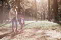 Nice walk with mom. A little curly girl is walking with her mother in forest