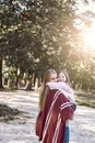 Happy, girl huggs her beautiful mother near lake