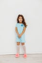 Little curly haired girl in blue dress and white knee socks