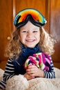 Little curly-haired girl in ski glasses sitting on a big teddy polar bear. Shot indoors Royalty Free Stock Photo