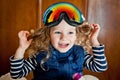 Little curly-haired girl in ski glasses sitting on a big teddy polar bear. Shot indoors Royalty Free Stock Photo