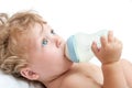 Little curly-headed baby sucks a bottle Royalty Free Stock Photo