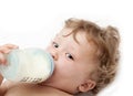 Little curly-headed baby sucks a bottle Royalty Free Stock Photo