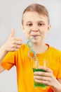 Little cut boy drinking a fresh green lemonade through straw Royalty Free Stock Photo