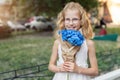 Little cute adorable blond caucasian little female child girl portrait hold beautiful fresh blue hydrangea bouquet Royalty Free Stock Photo