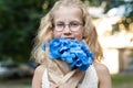 Little cute adorable blond caucasian little female child girl portrait hold beautiful fresh blue hydrangea bouquet Royalty Free Stock Photo