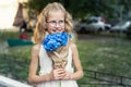 Little cute adorable blond caucasian little female child girl portrait hold beautiful fresh blue hydrangea bouquet Royalty Free Stock Photo