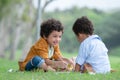 Little cute African American curly hair children boys sitting and have fun drawing with color pencils while picnic at park Royalty Free Stock Photo