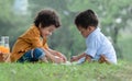 Little cute African American curly hair children boys sitting and have fun drawing with color pencils while picnic at park Royalty Free Stock Photo