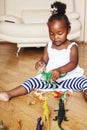 Little cute african american girl playing with animal toys at home, pretty adorable princess in interior happy smiling Royalty Free Stock Photo