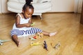 Little cute african american girl playing with animal toys at home, pretty adorable princess in interior happy smiling Royalty Free Stock Photo