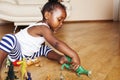 Little cute african american girl playing with animal toys at home, pretty adorable princess in interior happy smiling Royalty Free Stock Photo