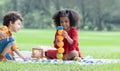 Little cute African children boy and girl sitting and have fun playing fruits building while picnic at park together. Lifestyle, Royalty Free Stock Photo