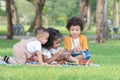 Little cute African children sitting and have fun playing xylophone making music sound while picnic at park together. Royalty Free Stock Photo