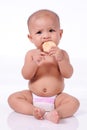 A Little Cute Asian Baby girl eating biscuit wearing diaper Royalty Free Stock Photo