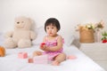 Little cute asian baby girl sitting on bed playing Royalty Free Stock Photo
