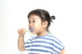 A little cute asian girl brushing her teeth isolated on white background. Royalty Free Stock Photo